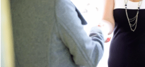 Torsos of two women shaking hands.